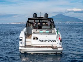 A sleek yacht named MeryRose navigates the waters with guests onboard, offering stunning views of Mount Vesuvius in the background — perfect for luxury cruising experiences.