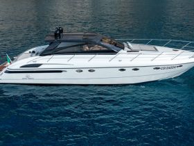 A sleek yacht glides through clear waters, showcasing its elegant design and perfect for luxurious outings on the sea.