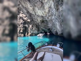 Guests enjoy a stunning view from their boat as they approach a cave, surrounded by crystal-clear waters — a perfect setting for adventure and exploration.