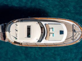 A stunning aerial view of a luxurious yacht showcasing its sleek design and spacious deck, perfect for relaxing on the open water.