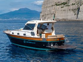A sleek yacht named 'Ilery' cruising through clear waters, with stunning cliffs in the background — perfect for exploring coastal destinations.