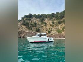 A sleek boat anchored in clear turquoise waters, surrounded by stunning rocky cliffs — perfect for exploring coastal destinations.
