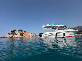 A stunning view of a boat docked near a picturesque island, showcasing the clear waters and beautiful coastal scenery.