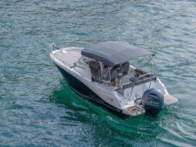 A sleek center console boat captured in clear waters, showcasing its stylish design and perfect for day trips or fishing adventures.