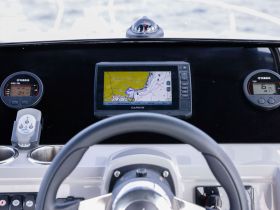 A detailed view of the helm console on a boat, featuring navigation equipment and controls, ideal for those interested in boating technology and navigation.