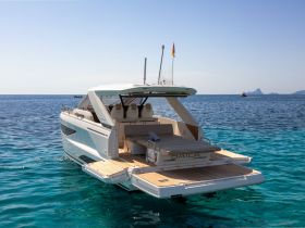 A stunning view of a sleek yacht cruising through crystal-clear waters, showcasing its elegant design and inviting deck space.