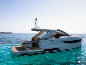 A sleek yacht glides through crystal-clear waters, showcasing its elegant design and luxurious features — perfect for upscale boating experiences.