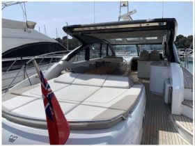 A spacious and stylish interior of a yacht featuring comfortable seating and a modern lounge area, perfect for relaxing on the water.