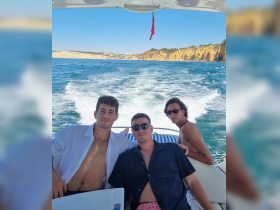 A group of friends enjoys a sunny day on the water, capturing the essence of a fun boating adventure along the beautiful coastline.
