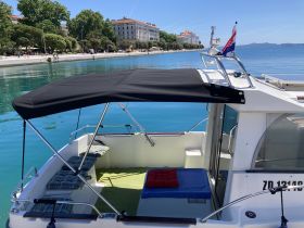 A cozy interior view of a boat featuring comfortable seating and shade, perfect for relaxing on the water.