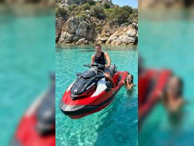 A couple enjoys a thrilling moment on a jet ski in crystal-clear waters, capturing the essence of summer fun and adventure.