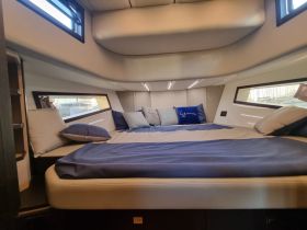 A cozy cabin interior featuring a comfortable bed and plush pillows, perfect for relaxing on a luxury yacht.