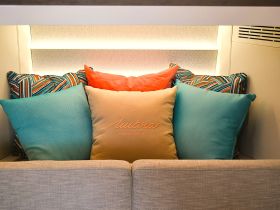 A cozy seating area inside a boat, adorned with colorful cushions, perfect for relaxation and comfort while enjoying the sea.
