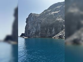 A stunning view of a rocky coastline with clear blue waters, perfect for showcasing the natural beauty of the area during a boating adventure.