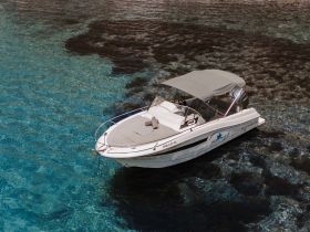 A stunning aerial view of a sleek speedboat anchored in crystal-clear waters, perfect for exploring coastal destinations or enjoying a day on the water.