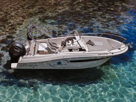 A stunning aerial view of a Sun Cruiser 700 anchored in crystal-clear waters, showcasing its sleek design and inviting deck space.