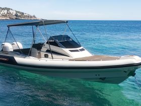 A sleek speedboat glides through crystal-clear waters, showcasing its modern design and perfect for thrilling adventures on the sea.