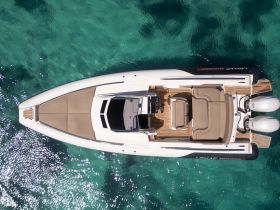 A stunning aerial view of a sleek speedboat gliding over crystal-clear waters, showcasing its elegant design and spacious deck — perfect for thrilling adventures on the water.