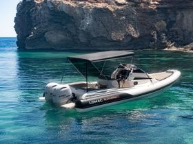 A sleek speedboat glides through crystal-clear waters, showcasing its elegant design against a stunning rocky backdrop — perfect for exploring coastal destinations.