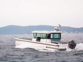 A sleek speedboat glides through the water, showcasing its modern design and powerful engine, perfect for thrilling adventures on the open sea.