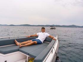 A man relaxes on the deck of a boat, enjoying the serene sea view — perfect for leisurely outings on the water.