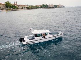 An aerial view of a sleek speedboat cruising through calm waters, showcasing its modern design and perfect for adventurous outings on the sea.