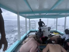 A lively group aboard a boat in Negril, engaged in fishing activities — a perfect snapshot of adventure on the water.