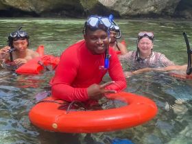 A lively group enjoys snorkeling in clear waters, showcasing a fun underwater adventure with friends.