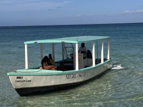 A couple enjoys a relaxing moment aboard a boat in the clear waters of Negril, perfect for adventure tours and scenic experiences.