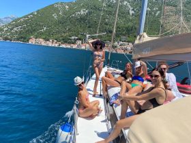 A lively group of friends enjoys a sunny day sailing, showcasing fun and camaraderie on the water — perfect for summer adventures.