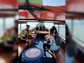 A lively interior view of a boat with guests seated, including children in life jackets, enjoying a scenic ride. Perfect for family outings on the water.