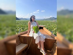 A woman enjoys a serene moment on a boat surrounded by lush lily pads on a beautiful lake, perfect for nature lovers and scenic boat tours.