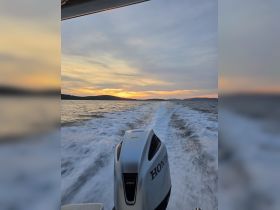 A stunning sunset view from the back of a boat, showcasing the powerful Honda engine as it cuts through the water — perfect for those seeking adventure on the open sea.