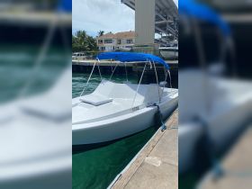 A sleek speedboat docked at the marina, showcasing its clean lines and vibrant blue canopy — perfect for a day out on the water.