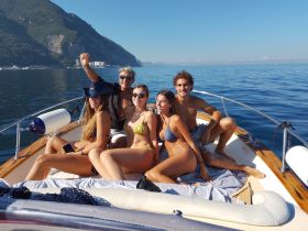 A cheerful group of friends enjoys a sunny day on the boat, capturing the perfect moment of fun and camaraderie on the water.