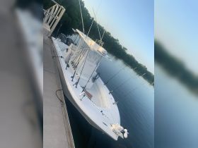A sleek speedboat docked peacefully at the marina, showcasing its fishing gear and pristine design, perfect for a day on the water.