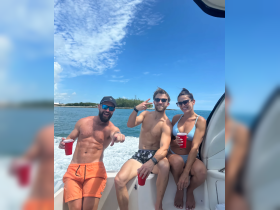 A lively group enjoys a fun day on the water, sipping drinks and soaking up the sun aboard a boat — perfect for summer adventures and celebrations.