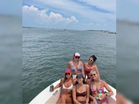A fun group of friends enjoys a sunny day on the water, capturing the essence of summer adventures aboard a boat.