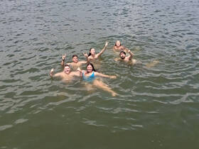 A lively group enjoys a refreshing swim in the water, showcasing the fun and camaraderie of a perfect day on the water.