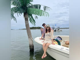A joyful group poses on the bow of a boat, enjoying a day on the water — perfect for family outings and memorable adventures.