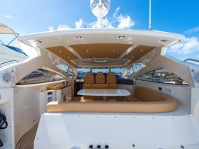 A spacious and elegantly designed interior of a yacht, featuring comfortable seating and a helm area, perfect for relaxing and enjoying time on the water.