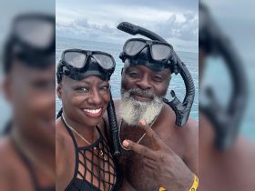 A joyful couple poses for a selfie while snorkeling in clear waters, showcasing their adventurous spirit and love for marine exploration.