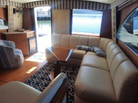 Interior view of a cozy boat cabin featuring comfortable seating and a stylish lounge area, perfect for relaxing while enjoying the water.