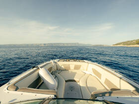 A serene view from the front of a yacht, showcasing comfortable seating and expansive ocean views — perfect for a relaxing day on the water.