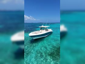 A stunning speedboat anchored in crystal-clear turquoise waters, perfect for exploring beautiful coastal destinations.