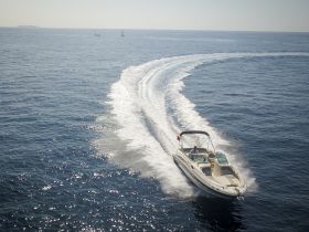 A speedboat glides through the shimmering waters, showcasing the thrill of boating adventures on the open sea.