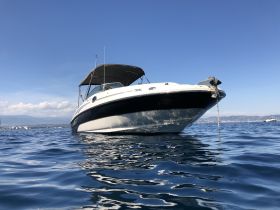 A striking view of a speedboat anchored in calm waters, showcasing its sleek design against a clear blue sky — perfect for summer adventures on the water.