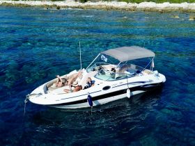 A group enjoys a sunny day on a boat, relaxing and sunbathing in crystal-clear waters — an ideal setting for summer adventures.