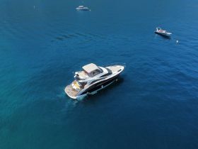 A stunning aerial view of a luxurious yacht cruising through clear blue waters, perfect for showcasing elegant boating experiences.