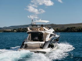 A stunning view of a yacht cruising through clear waters, showcasing its elegant design and the beauty of the surrounding landscape.